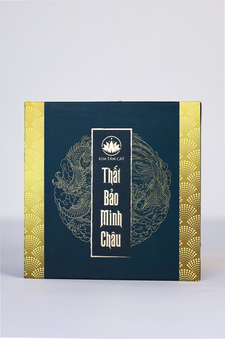 Hộp Thất Bảo Minh Châu nhìn chính diện, nền xanh than in rồng phượng nhũ vàng và logo Kim Tâm Cát
